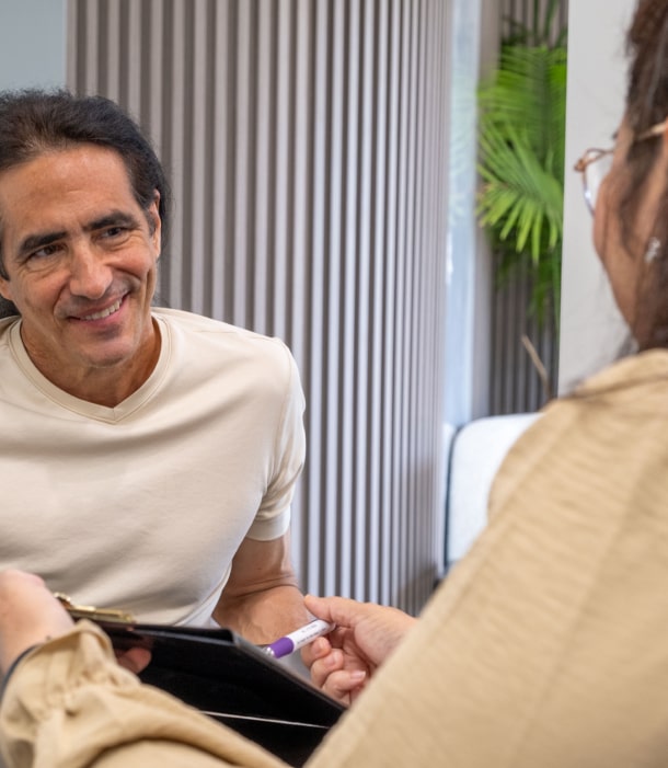 A photo of happily smiling patient while talking with our team member