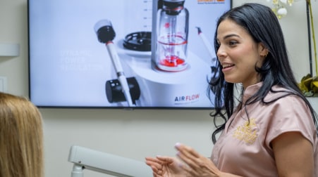 A photo of our team members talking with patient when she sitting in the dental chair